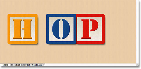 Aligning the bottom edges of the three blocks in the document. Image © 2011 Photoshop Essentials.com